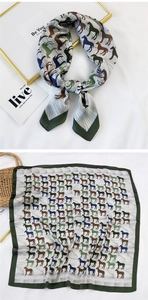 Detail of silk-feel square scarf featuring horse prints and dark green border for styling