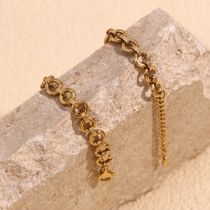 Macro detail of a 14K gold-plated stainless steel chunky link anklet on stone