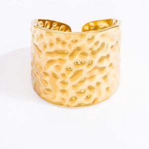 Detailed view of 18k gold plated stainless steel cuff with unique hammered texture surface