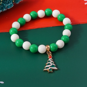 Close-up of green and white beaded Christmas bracelet with a golden Christmas tree pendant