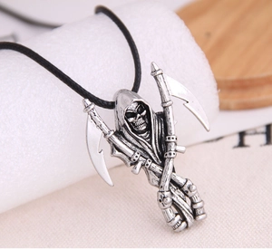 Macro shot of a silver Reaper pendant with crossed scythes on a black cord necklace