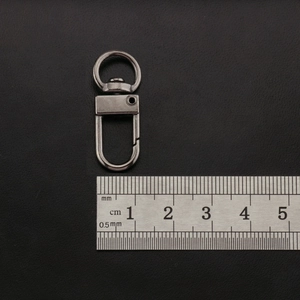 Detailed macro of 38mm gunmetal zinc alloy lobster clasp with swivel ring on leather
