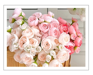 Close-up of realistic faux roses in pink and white inside a rustic woven bamboo basket