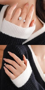 Detail view of gold and silver open rings with zircon-studded double clover designs