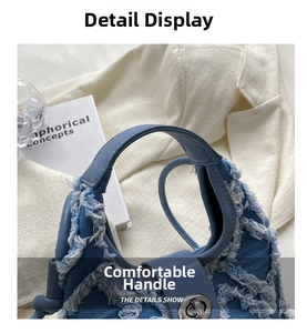Detailed view of frayed denim edges and silver metal twist lock on blue handbag
