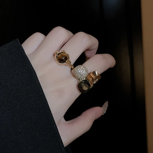 Close-up of vintage gold-plated rings with amber zircon stones on model's hand