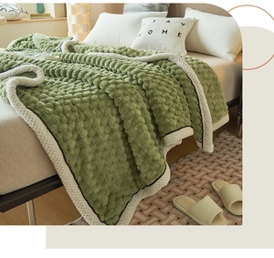 Detail of green bubble velvet blanket showing soft 3D plush texture and white hemmed edges