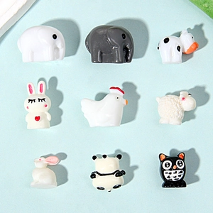 Nine mini resin animal figurines including cow, panda, and sheep on a blue background