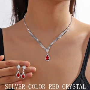 Detail showing the red water drop crystal necklace and earrings set worn by a model