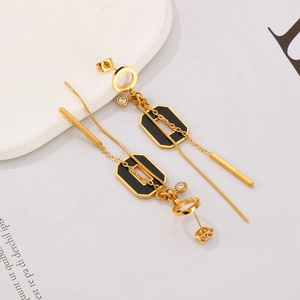Vue macro de boucles d'oreilles pompons dorées avec octogones noirs et détails en zircon