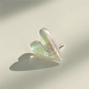 Macro shot of iridescent heart-shaped earrings with mermaid pearl luster and silver finish