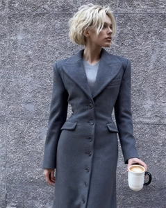 Dettaglio dell'elegante cappotto di lana grigio scuro con cuciture e tasche raffinate