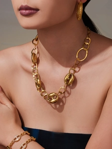 Gros plan du collier grain de café en or 18 carats et boucles d'oreilles sur un modèle