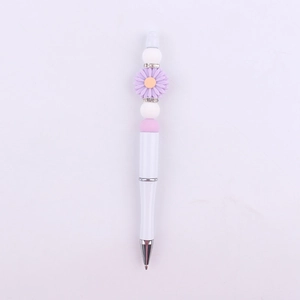 Detailed view of DIY beaded pen featuring a purple daisy and pink silicone beads