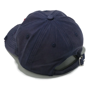 Detail of navy blue vintage baseball cap featuring distressed holes and metal buckle strap