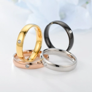 Polished stainless steel rings in gold, silver, rose gold, and black with a small inset gem