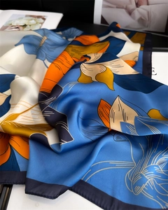 Detail view of the floral print silk scarf showing its smooth texture and elegant drape