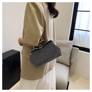 Donna elegante con borsa da sera nera con strass e tracolla a catena argento