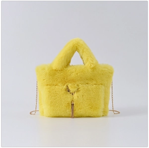 Detail of vibrant yellow faux rabbit fur handbag with golden deer charm and tassel