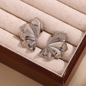 Macro view of silver geometric petal stud earrings placed in a premium wooden jewelry box