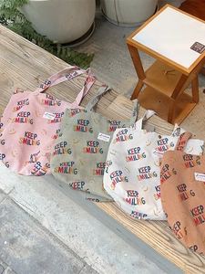 Corduroy shoulder tote bags in four colors with Keep Smiling print and logo detail