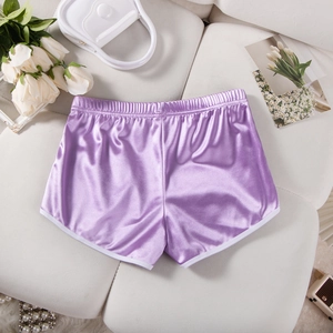 Detail view of purple satin athletic shorts with white trim on a white decorative background