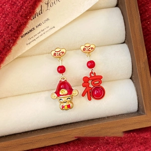 Detailed close-up of asymmetric God of Wealth and Fu character stud earrings on velvet