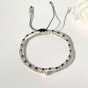 Detail view of handmade Miyuki bead bracelets featuring a single freshwater pearl accent