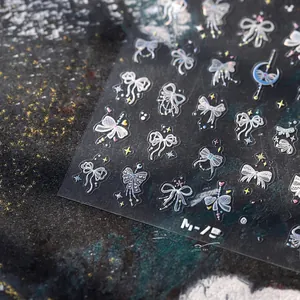 Vue macro des stickers ongles M-757 nœuds holographiques avec étoiles sur fond pierre sombre