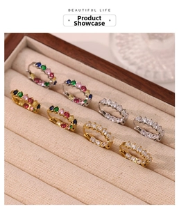 Detail of gold and silver hoop earrings with colorful zircon stones in a velvet box