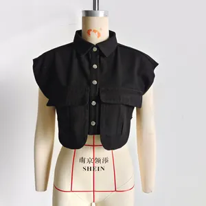 Détails d'un gilet en jean noir avec boutons argentés et grandes poches à rabat