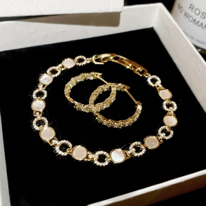 Détail de parure de bijoux dorés avec nacre et zircons pavés dans un coffret cadeau