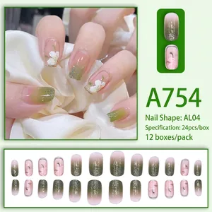 Green and pink gradient press-on nails with white floral patterns and shimmering glitter