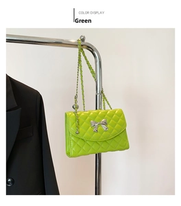 Détail du sac bandoulière vert matelassé avec boucle nœud argenté et chaîne