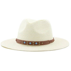 Close-up of straw fedora hat with brown leather band, rivets and turquoise beads