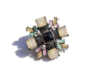 Detailed close-up of retro cross brooch with black square gem and champagne crystals