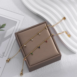 Elegant gold titanium steel bracelets with colorful round zircons on a jewelry box