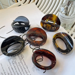 Selection of six tortoiseshell resin hair claws displayed on a magazine for a stylish look