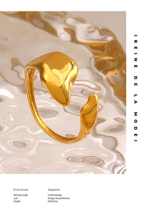 Detail shot of golden liquid-style irregular open ring with warm amber lighting and reflections