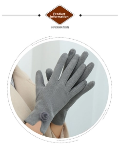 Detail of grey knitted winter gloves featuring soft decorative pompom and thermal texture