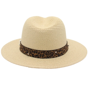 Macro detail of panama hat featuring leopard print ribbon and white pearl ornament