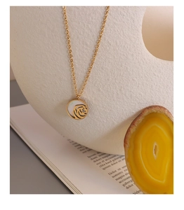 Detailed close-up of 18k gold plated necklace with white rose zircon pendant on a display