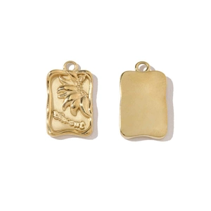 Macro detail of gold rectangle pendant with flower relief and Dream engraving