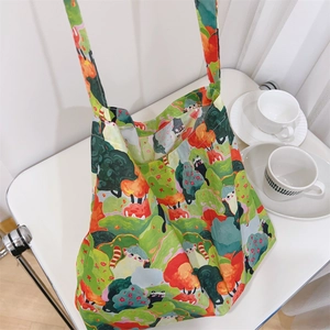 Detail of printed cotton tote bag featuring forest animal art hanging on a white chair