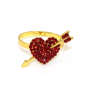 Detailed view of heart-shaped napkin ring with red rhinestones and arrow design