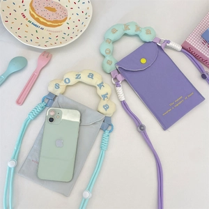 Close-up of contrast embroidery and bubble handle on the canvas phone bag