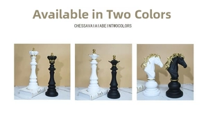 Detail of resin chess statues showing gold crown accents on black and white king and queen pieces