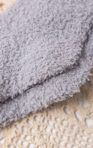 Detailed macro view of gray coral fleece fabric texture on a delicate lace background