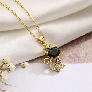 Dettaglio della collana d'oro con pendente a gatto nero, corona e pietra su seta morbida