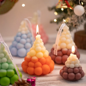 Creative Christmas tree scented candles in vibrant gradients with festive ribbon bows